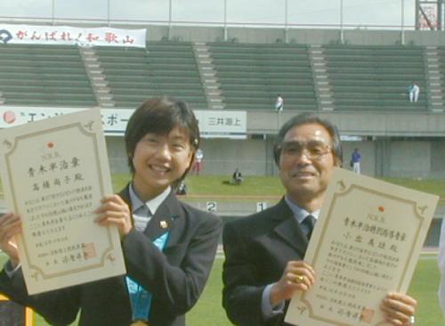 2000年10月16日、富山国体の陸上競技会場で表彰された女子マラソンの高橋尚子は、国民栄誉賞授与に関し快諾の意向を示した。右は小出義雄監督