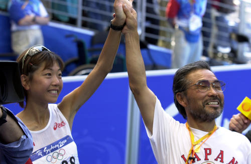 2000年9月24日、シドニー五輪女子マラソンで金メダルを獲得した高橋尚子（左）の手を高々と掲げ、満面の笑みを見せる小出義雄監督