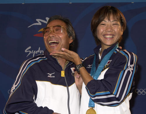 2000年9月24日、シドニー五輪女子マラソンで金メダルを獲得し表彰式のあとに会見した高橋尚子（右）はヒゲを剃った小出義雄監督のアゴをなでて笑顔