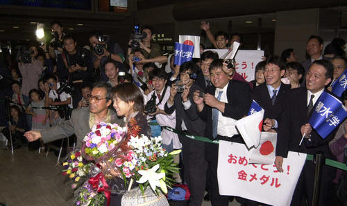 2000年10月2日、シドニー五輪女子マラソンで金メダルを獲得し帰国した高橋尚子と小出義雄監督（左）は出迎えにきた多くのファンと記念撮影