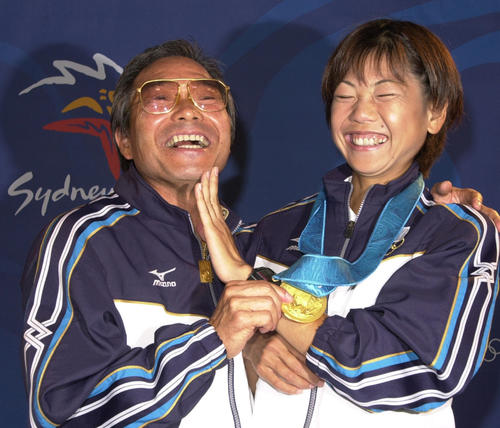 00年9月、シドニー五輪女子マラソン表彰式の後、ひげをそったアゴを高橋尚子になでられ笑顔の小出義雄さん