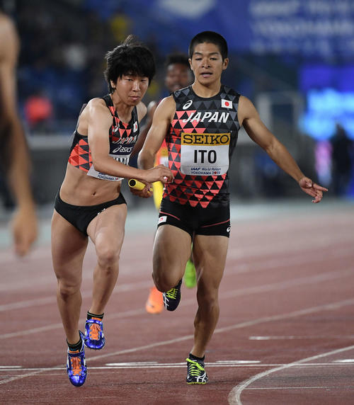 混合1600メートルリレーの予選で、2走青山（左）にバトンパスする1走伊東（撮影・鈴木みどり）