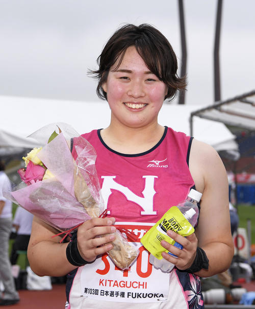 女子やり投げで優勝し、花束を手に笑顔の北口榛花（共同）