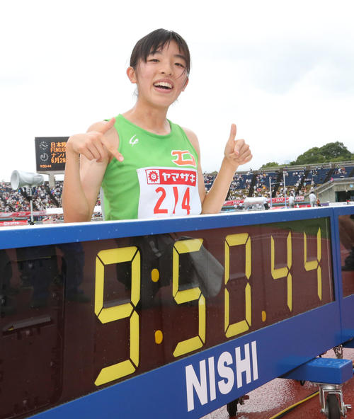 女子3000メートル障害　決勝　優勝した吉村はタイム表示の前で笑顔（撮影・梅根麻紀）