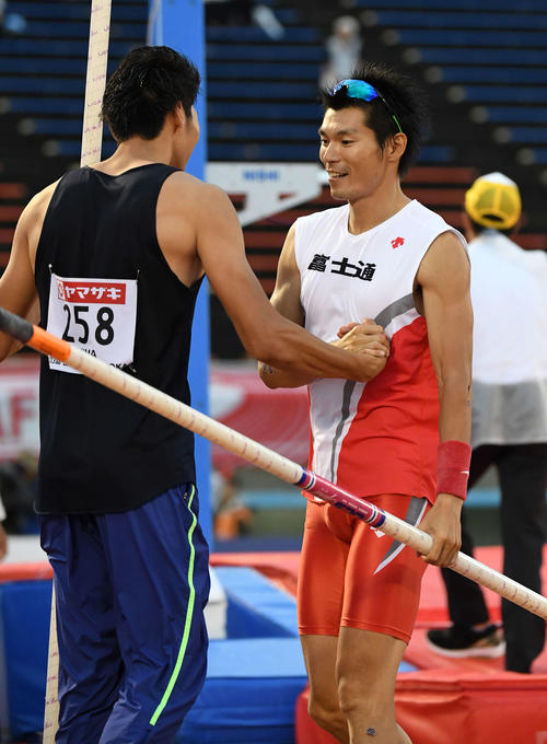 男子棒高跳びで、競技を終えた沢野（右）は江島と握手（撮影・鈴木みどり）