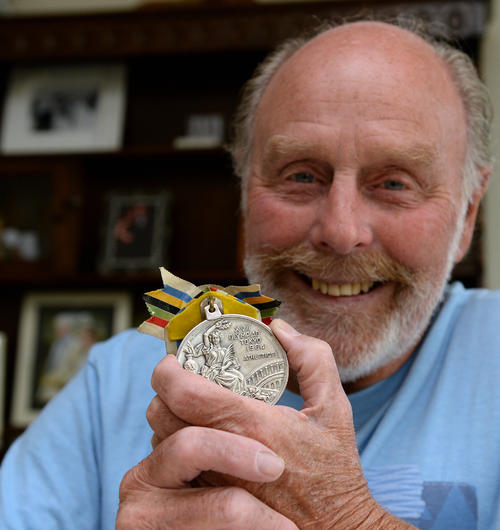 ベイジル・ヒートリーさんは、64年東京五輪のマラソンで獲得した銀メダルを手に笑顔を見せる（2014年7月7日撮影）