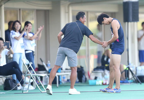 男子走り幅跳びで8メートル32を記録した橋岡（右）は恩師で日本記録保持者の森長氏の持つ日本記録を更新し、握手を交わした（撮影・河野匠）