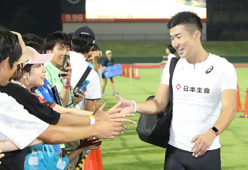 自身の記録9秒98には及ばなかったが、レース後集まった観客とタッチを交わしながら引き揚げる桐生（撮影・河野匠）