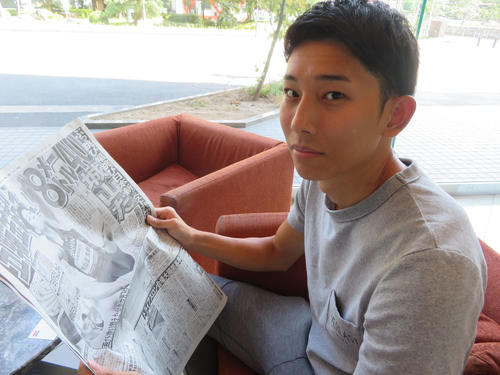 日本新記録から一夜明け、自身の記事が載る本紙を見る城山（撮影・上田悠太）