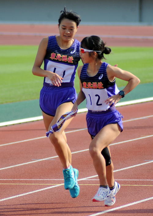 1位になった東北福祉大Bチームは2区・区間賞の金沢（左）がアンカー小高にタスキリレーする