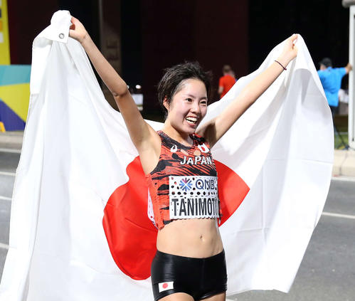 7位でゴールし日の丸を手に笑顔を見せる谷本（撮影・河野匠）