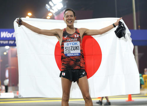 男子50キロ競歩で優勝し日の丸を手に笑顔を見せる鈴木（撮影・河野匠）