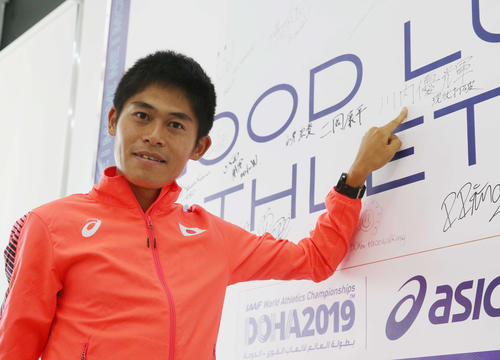 男子マラソン会見場外のボードにサインする川内（撮影・河野匠）