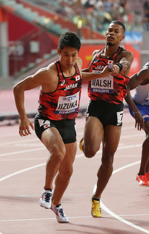 男子1600メートルリレー予選1組、2走の飯塚（左）にバトンをつなぐ1走のウォルシュ（撮影・河野匠）