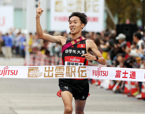 人さし指を突き上げ1位でゴールする国学院大アンカーの土方（撮影・前田充）
