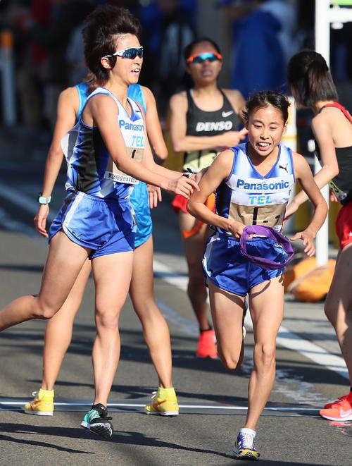 昨年の大会でパナソニック2区の内藤早紀子（手前左）から首位でたすきを受ける3区の渡辺菜々美