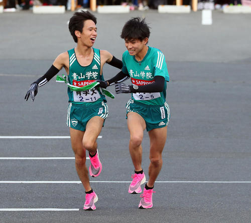 小田原中継所で青学大5区飯田（右）にたすきを渡す4区吉田祐（撮影・大野祥一）