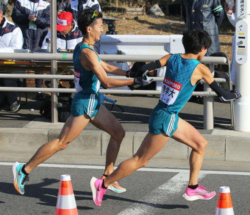 平塚中継所で青学大8区岩見（右）にたすきをつなぐ7区中村（撮影・河田真司）