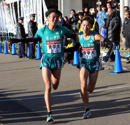小田原中継所で青学大7区中村（右）にたすきを渡す青学大6区谷野（撮影・大野祥一）