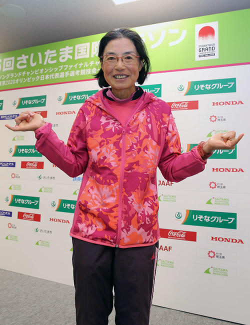 60歳以上の世界記録を更新する2時間56分54秒でゴールした弓削田さんは笑顔で記念撮影に納まる（撮影・河野匠）