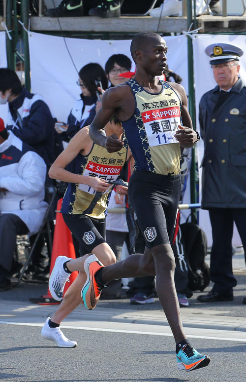 平塚中継所を1位で東京国際大4区佐伯（中央左）にたすきをつなぐ3区ヴィンセント（撮影・河田真司）