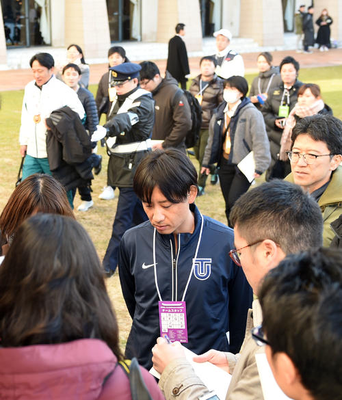 記者の質問にこたえる東洋大の酒井監督（手前）。後方左は会見場に向かう青学大の原監督（撮影・横山健太）