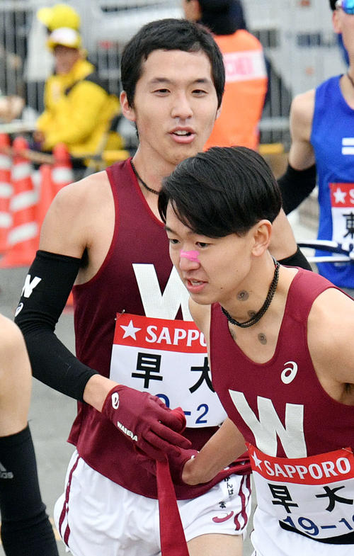 戸塚中継所で早大3区井川（手前）にたすきリレーする2区太田（撮影・滝沢徹郎）