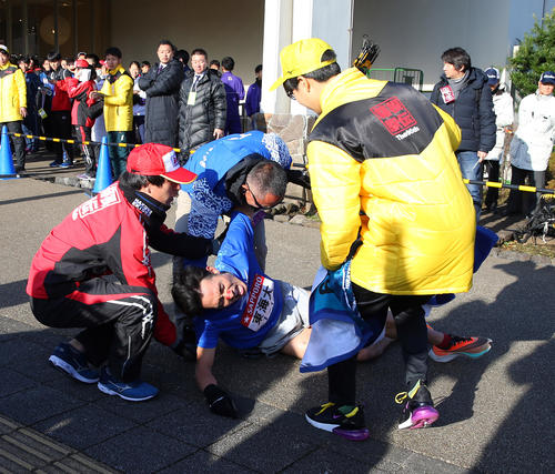 小田原中継所に到着して倒れ込み、係員に持ち上げられる東海大6区館沢（中央）（撮影・大野祥一）