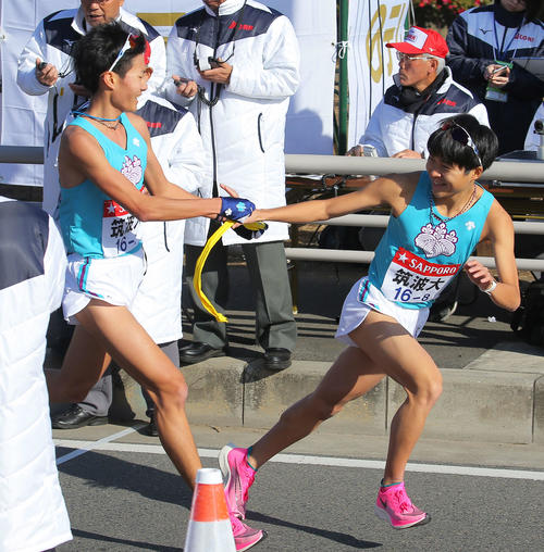 平塚中継所で筑波大8区伊藤（右）にたすきをつなぐ7区杉山（撮影・河田真司）