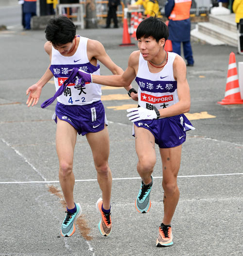 戸塚中継所でたすきリレーする駒大2区山下（左）と3区田沢（撮影・滝沢徹郎）