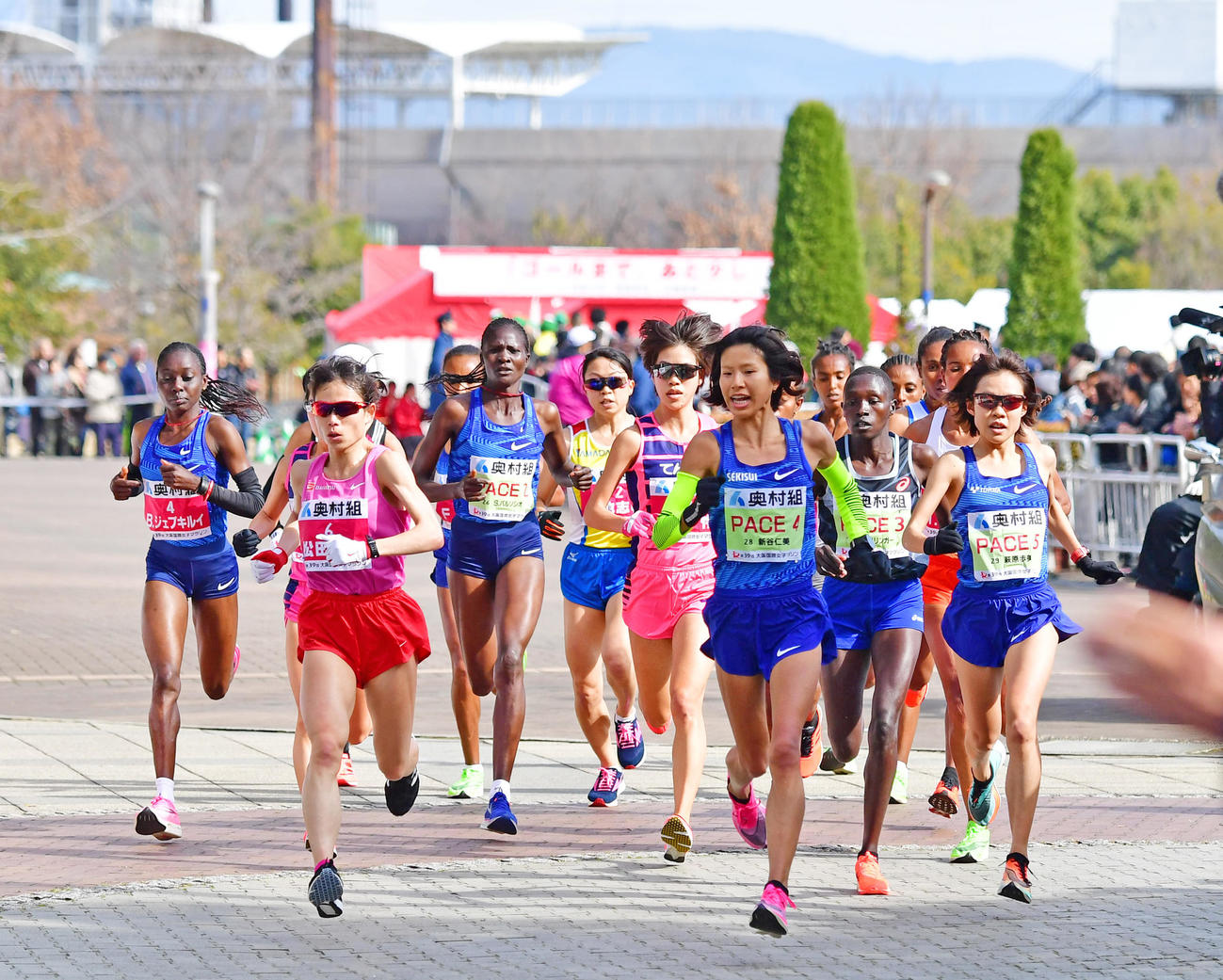 大阪国際女子マラソン　ペースメーカーの新谷仁美（PACEゼッケン）を先頭に長居を飛び出していく選手たち（撮影・清水貴仁）