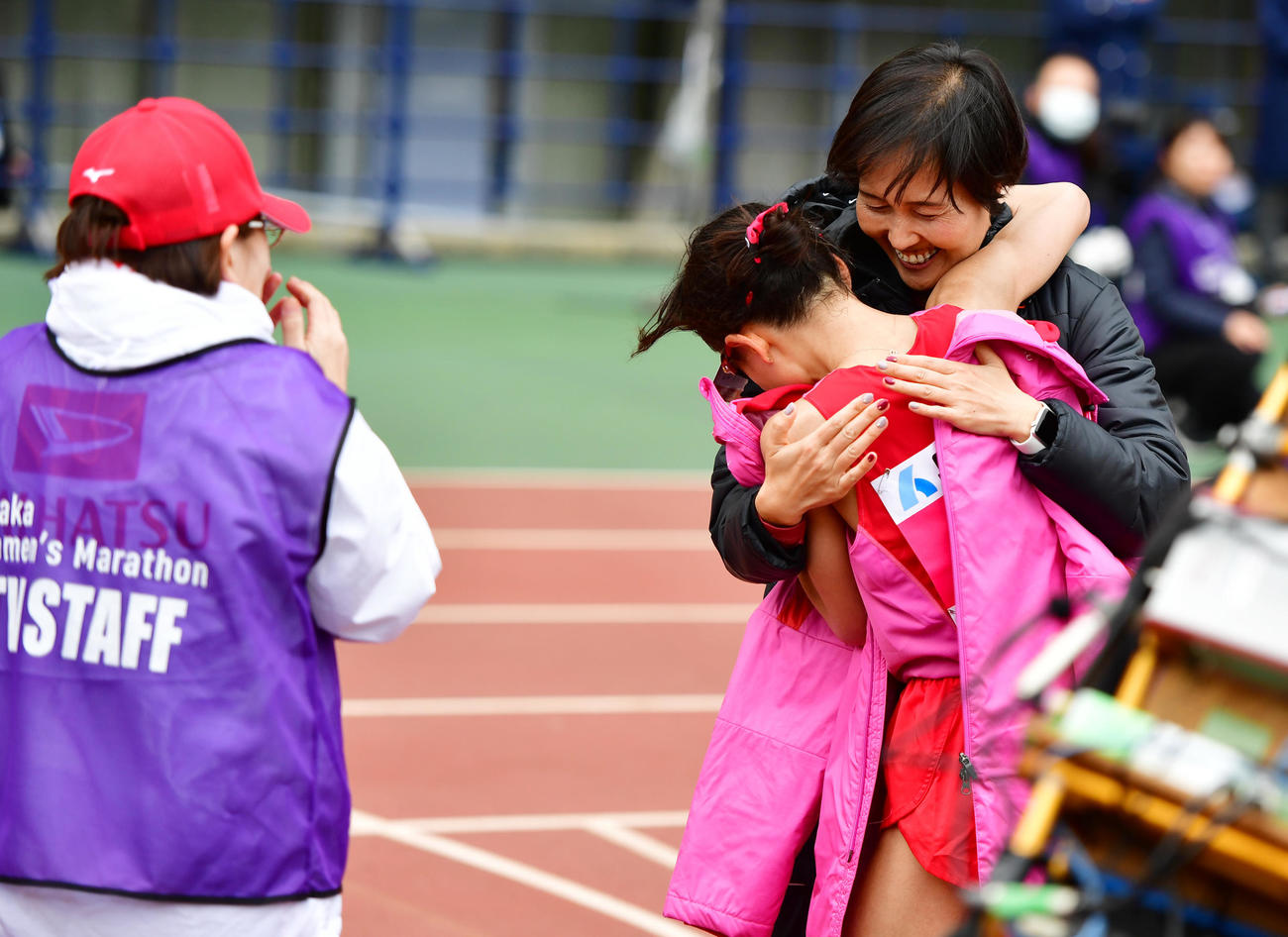 2時間21分47秒で優勝しダイハツ山中美和子監督（右奥）と抱き合う松田瑞生（撮影・清水貴仁）