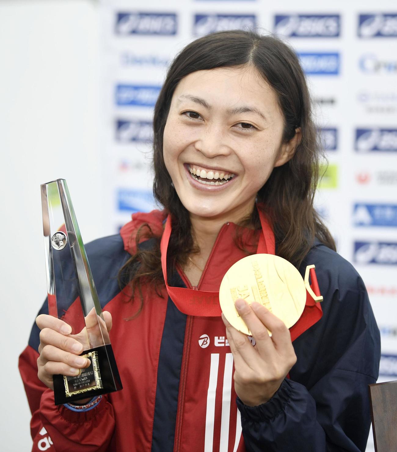 女子20キロで優勝して東京五輪代表に決まり、表彰式で笑顔を見せる岡田（共同）
