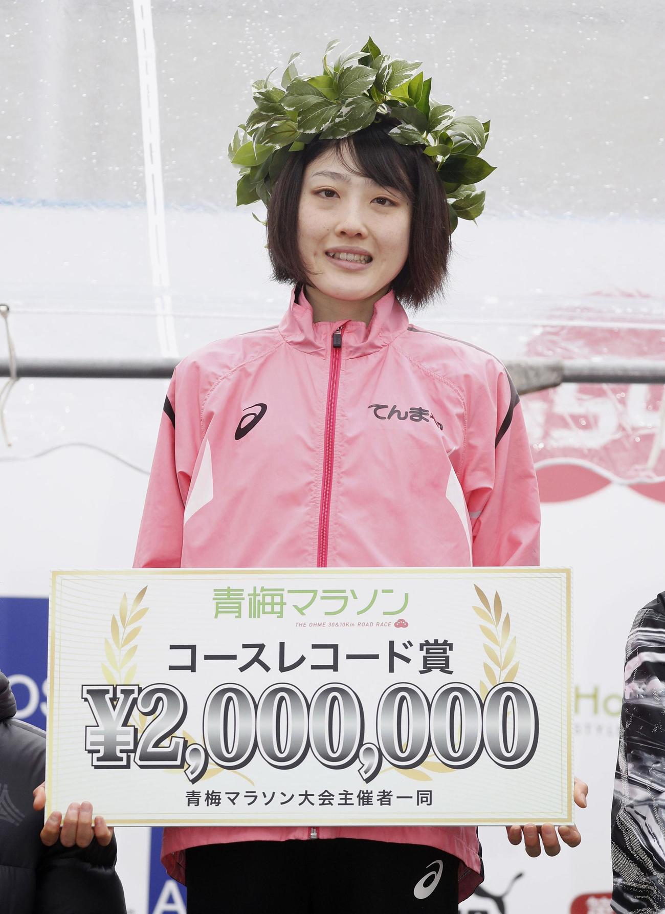 青梅マラソンで日本新記録をマークして優勝し、表彰式で笑顔を見せる前田穂南（共同）