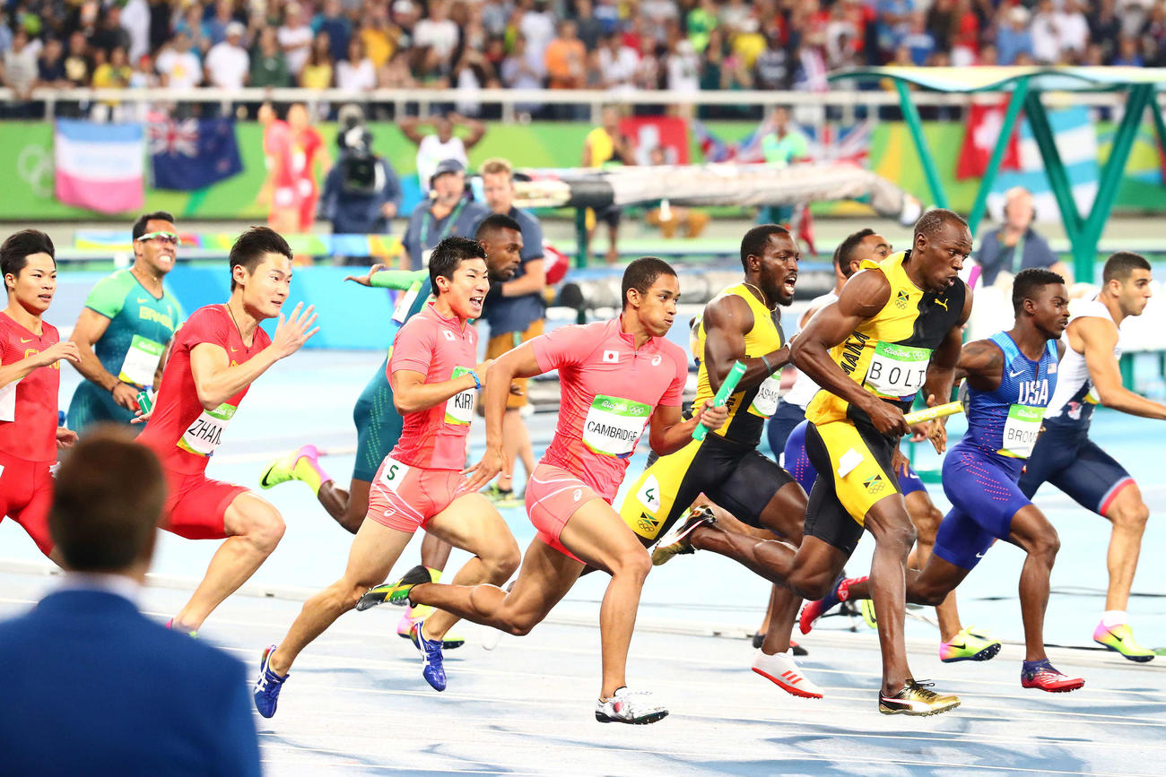 リオデジャネイロ五輪　男子400メートルリレー決勝で4走のケンブリッジ飛鳥にバトンを渡す3走の桐生祥秀（左から4人目）。右から3人目はウサイン・ボルト（2016年8月19日撮影）