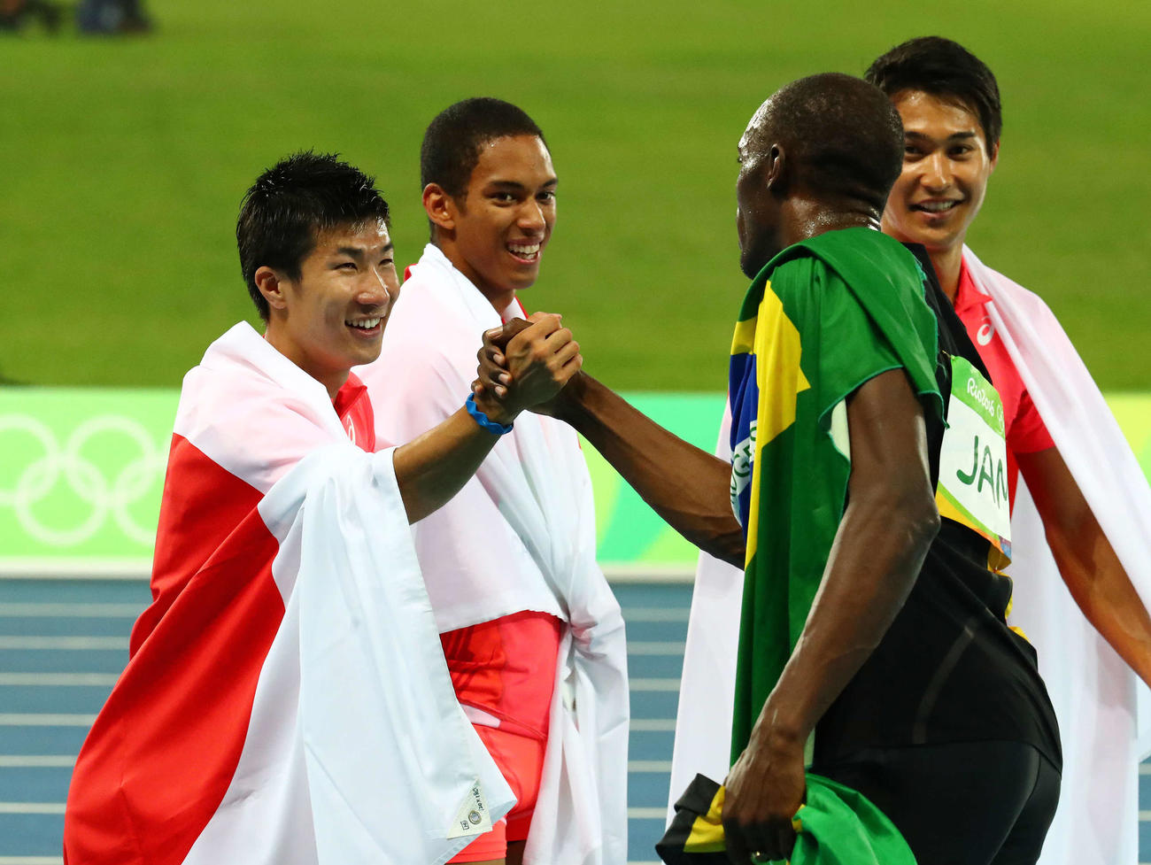 男子400メートルリレー決勝　優勝したジャマイカのボルト（右）と握手をかわす桐生。後方左からケンブリッジ、飯塚（2016年8月19日撮影）