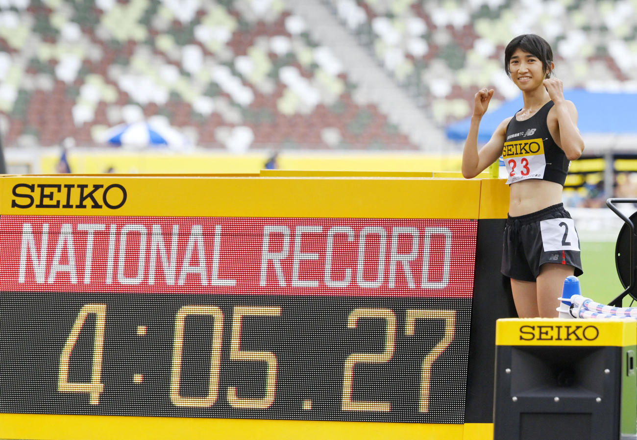 女子1500メートルで4分5秒27の日本新記録をマークして優勝し、笑顔でポーズをとる田中希実（共同）