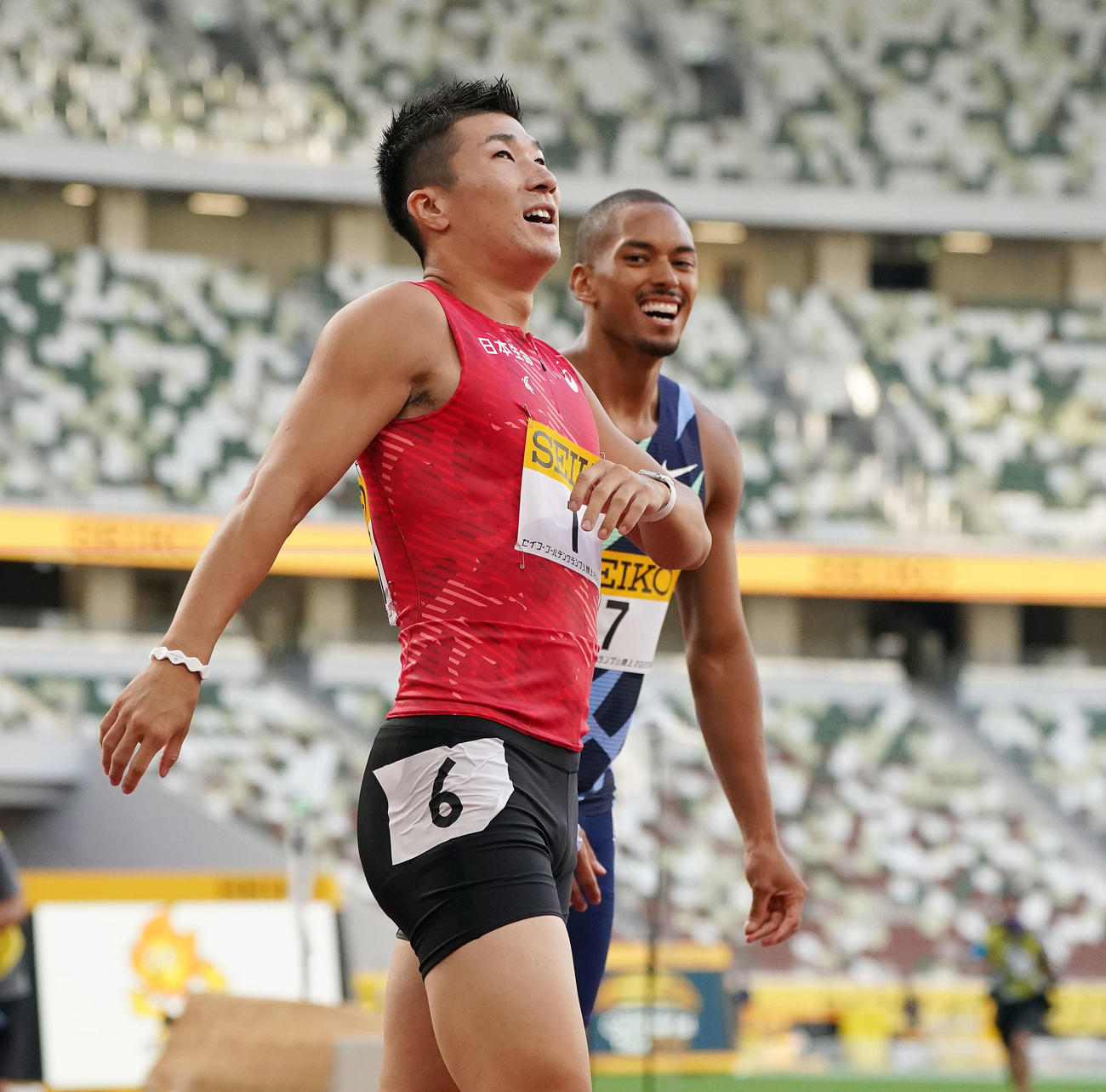 男子100メートル決勝で優勝した桐生（左）はゴール後に笑顔を見せる。右は2位のケンブリッジ（撮影・鈴木みどり）