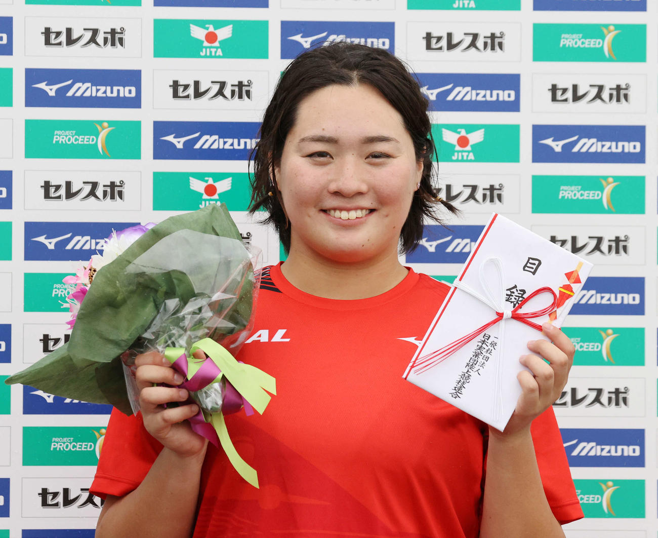 女子やり投げで優勝し花束、目録を手に笑顔を見せる北口（撮影・鈴木正人）