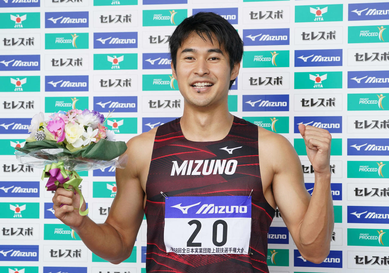 男子200メートルで優勝した飯塚は花束を手にガッツポーズ（撮影・鈴木みどり）
