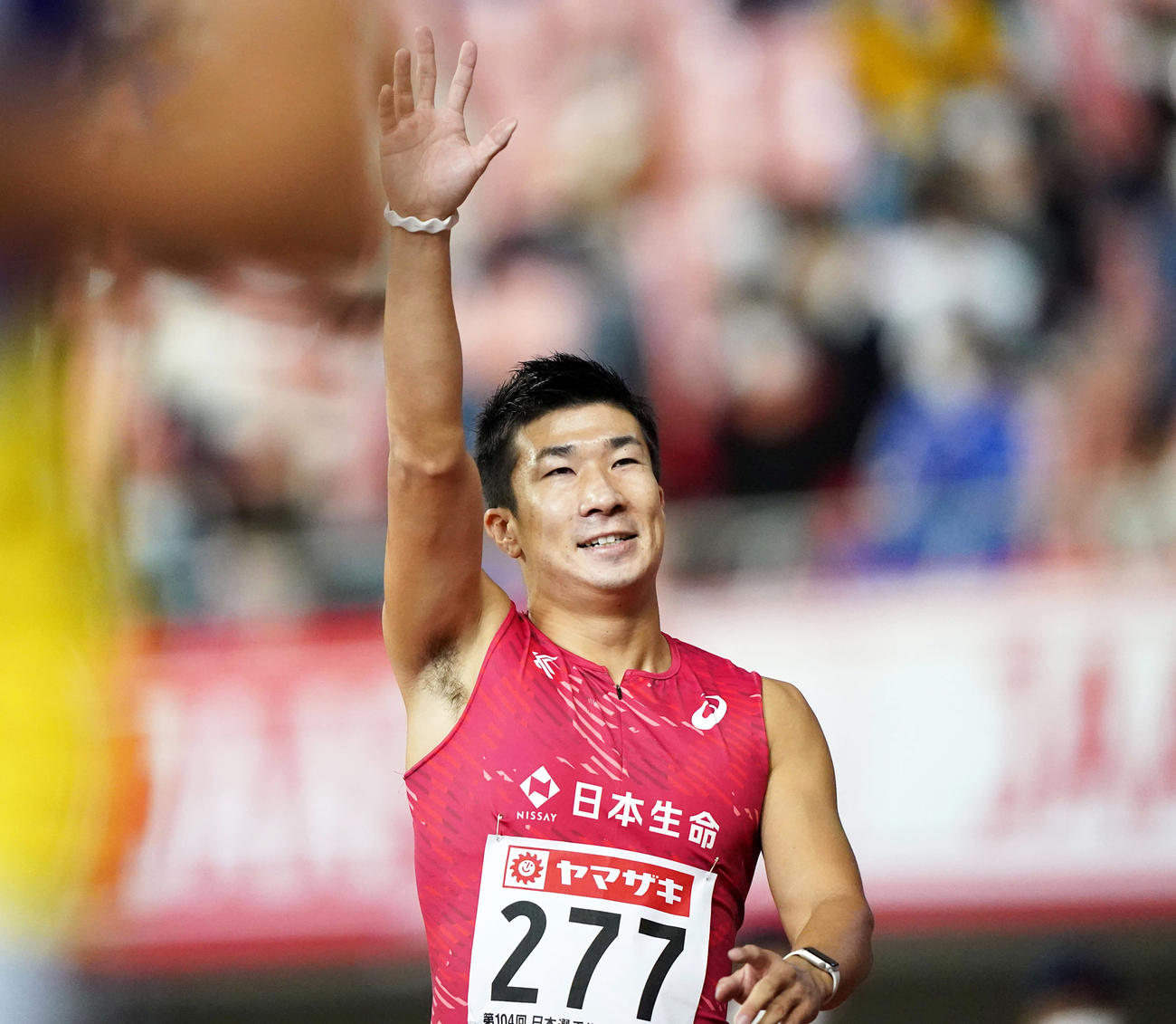 男子100メートルで優勝しスタンドに手を上げる桐生（撮影・江口和貴）