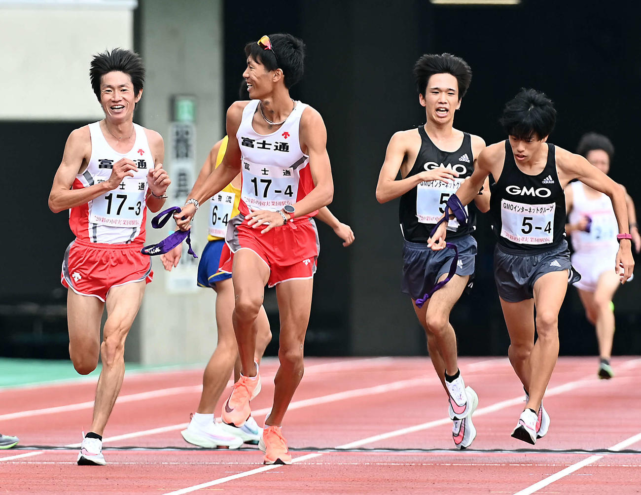 第3区　第4区の坂東悠汰（左から2人目）にタスキを渡す富士通中村匠吾。右から2人目はGMO吉田祐也（撮影・たえ見朱実）