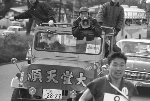 復路8区　力走する草萱鉄弥（手前＝4年、区間2位）に伴走車から拡声器で指示を出す順天堂大・帖佐寛章監督　　※この大会あたりから拡声器が使われ始めた＝1966年1月3日