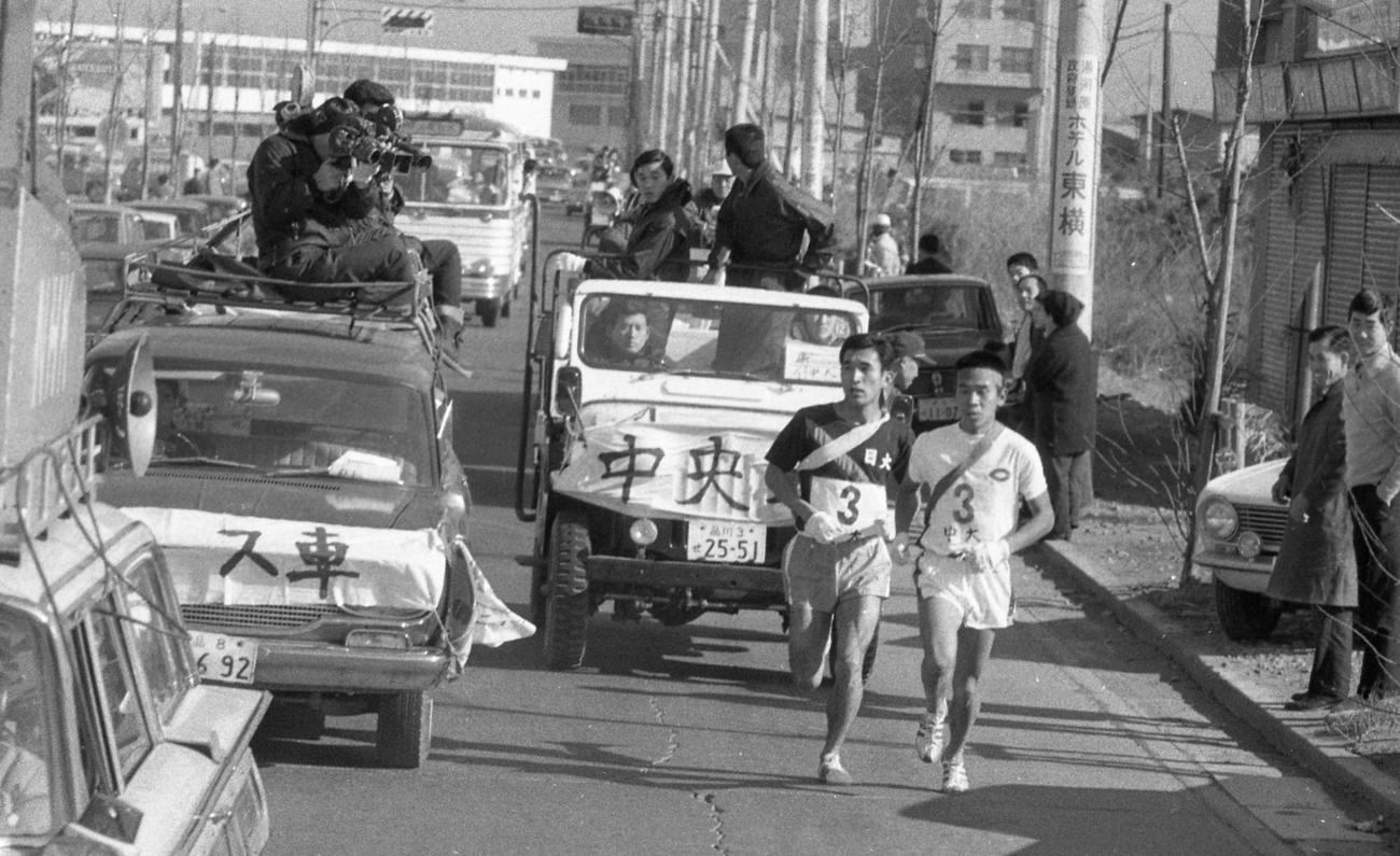 往路3区　戸塚中継所3位の日大・鈴木圀昭（左＝2年）は、国士舘大に続きトップの中大・薄寛（右＝1年）をとらえる＝1968年1月2日