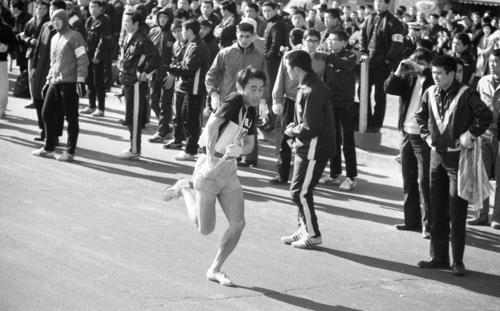 復路10区鶴見中継所　トップでタスキをもらった日大のアンカー土谷和夫主将（4年）は、左足アキレスけんの不安があるが元気に飛び出す＝1968年1月3日