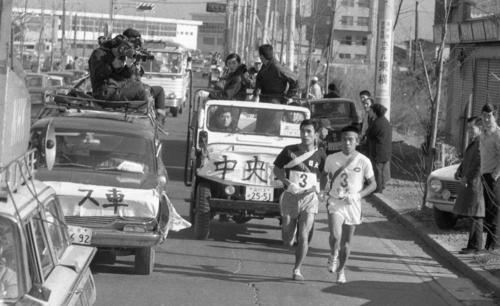 往路3区　戸塚中継所3位の日大・鈴木圀昭（左＝2年）は、国士舘大に続きトップの中大・薄寛（右＝1年）をとらえる＝1968年1月2日