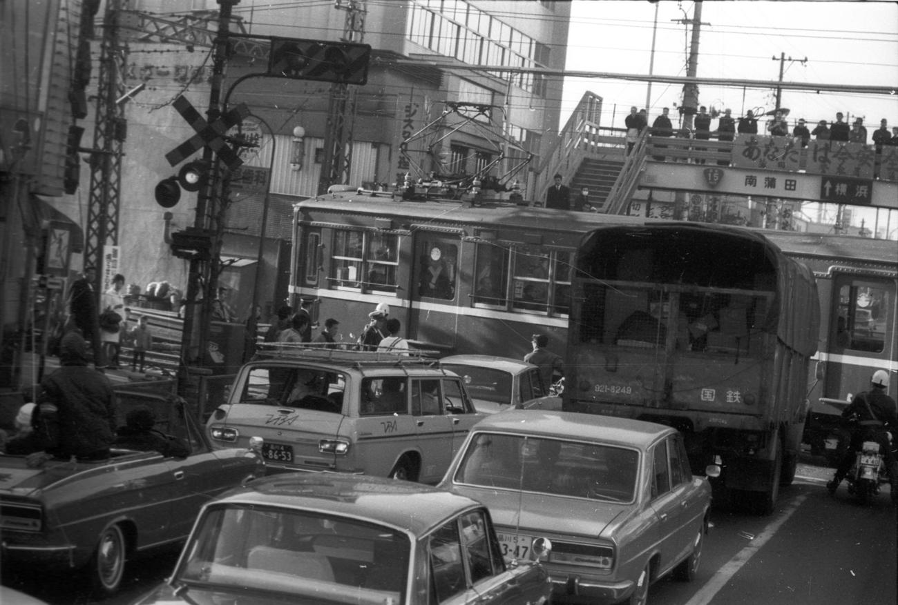 往路1区　トップを走る大東大・尾堂博（2年、区間1位）は、京浜急行踏切で電車通過のためストップ＝1969年1月2日