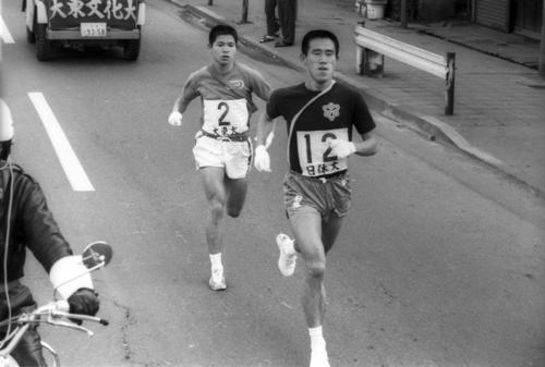 往路2区　鶴見中継所で13秒差2位でタスキをもらった日体大・小沢欽一（右＝4年、区間新1時間13分37秒）は2キロ地点で大東大・安田亘（左＝3年）をとらえ、一気に引き離す＝1972年1月2日