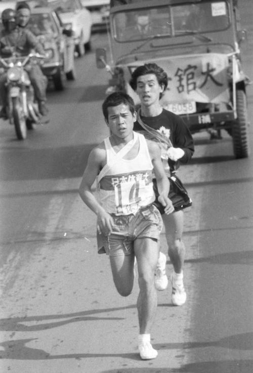 往路3区　戸塚中継所でトップに1分5秒差の3位でタスキもらった日体大・荒野吉之（手前＝1年）は、トップ国士舘大・阿部光幸（後ろ＝2年）をとらえると、並走する間を与えず一気に引き離しにかかる＝1973年1月2日