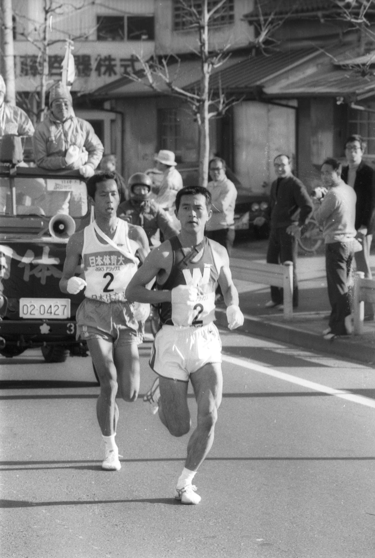 往路2区　トップに24秒差の3位でタスキを受けた早大・瀬古利彦（右＝3年、区間新1時間12分18秒）は2.9キロで日体大・中村孝生（左＝3年、区間2位）に並び、5.4キロでスパートしトップに躍り出る＝1979年1月2日
